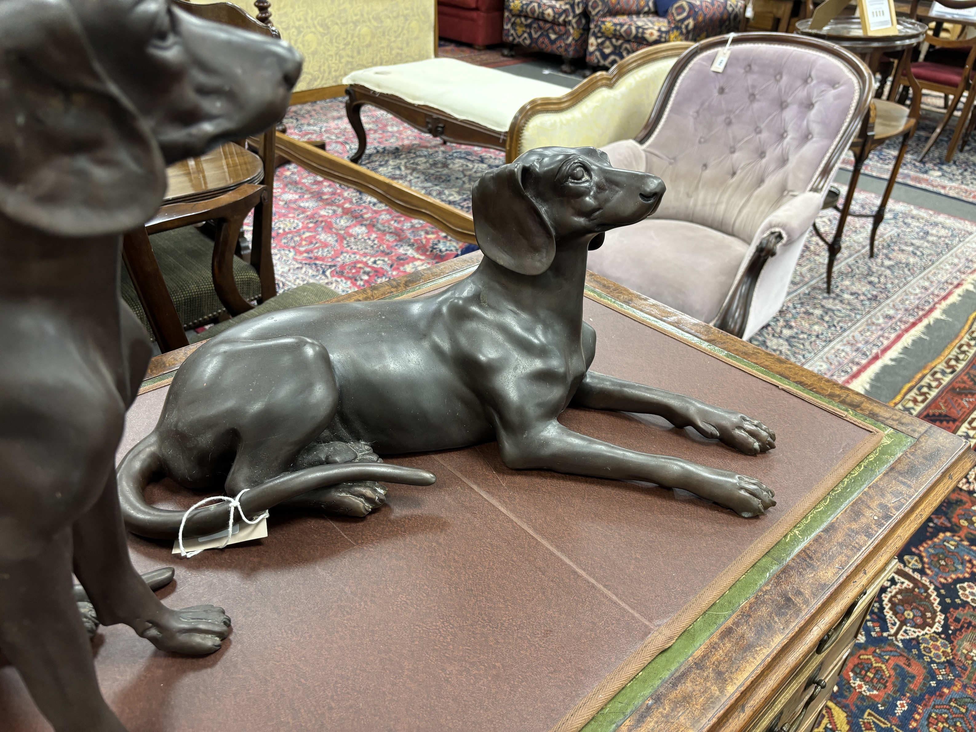 Two large bronze models of seated dogs, largest 57cm wide